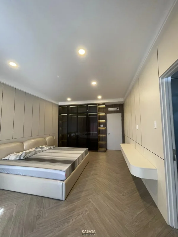 Phòng ngủ hiện đại tối giản với tủ âm tường và giường lớn.