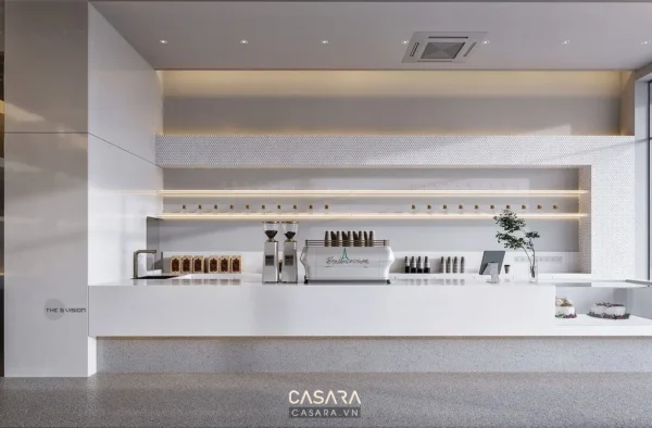 Quầy bar hiện đại, trắng tinh khôi với máy pha cà phê và cây xanh trang trí.