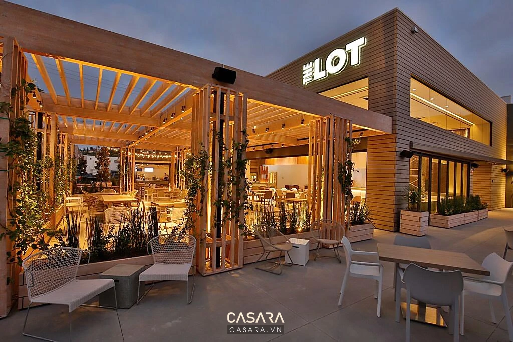 Mặt tiền quán cafe có biển hiệu cửa kính cây xanh và ánh sáng nhận diện thương hiệu
