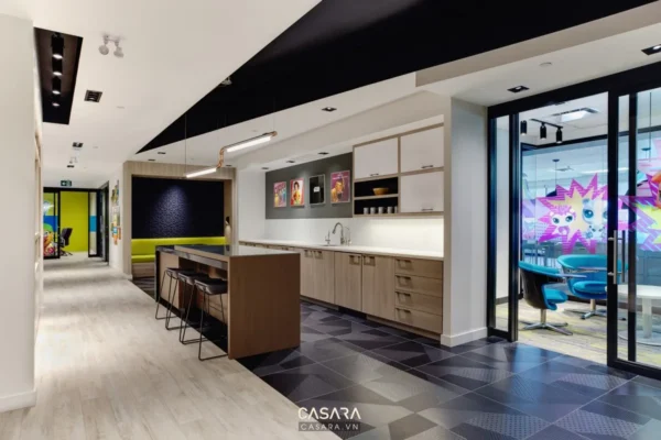 Khu vực bếp và quầy bar hiện đại trong không gian văn phòng sáng sủa.