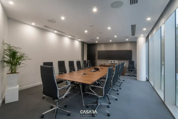 Phòng họp hiện đại với bàn hội nghị dài và ghế da cao cấp.