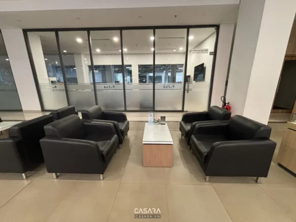 Phòng chờ rộng rãi với ghế sofa đen và cửa kính lớn.