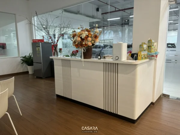 Quầy lễ tân hiện đại với hoa tươi trang trí trong văn phòng.