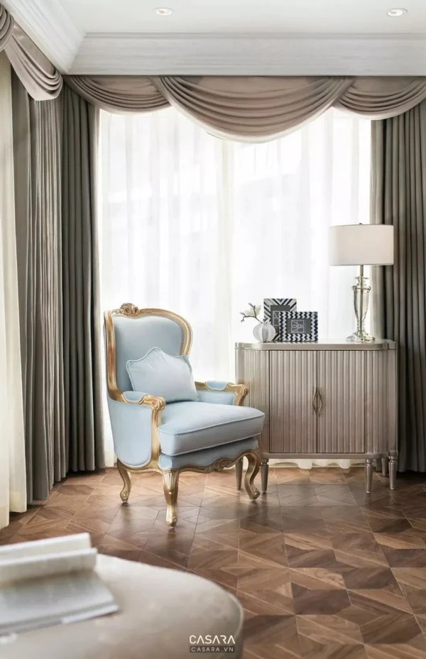 Góc phòng khách sang trọng với ghế bọc nhung và tủ gỗ tinh tế.