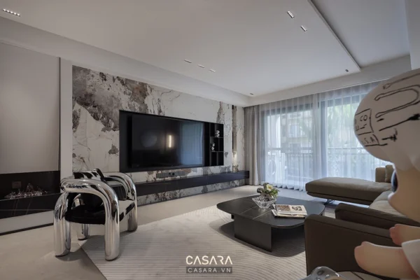 Phòng khách hiện đại với điểm nhấn từ bức tường đá và TV lớn.
