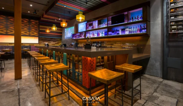 Quán bar hiện đại với quầy bar dài và ánh sáng ấm áp.