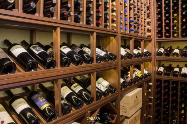 Tủ rượu gỗ chứa nhiều chai rượu vang với các nhãn mác khác nhau.