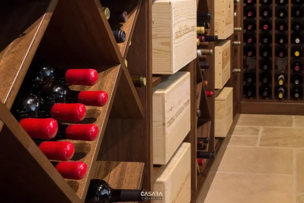 Tủ rượu gỗ với nhiều chai rượu đỏ và hộp gỗ trang trí.