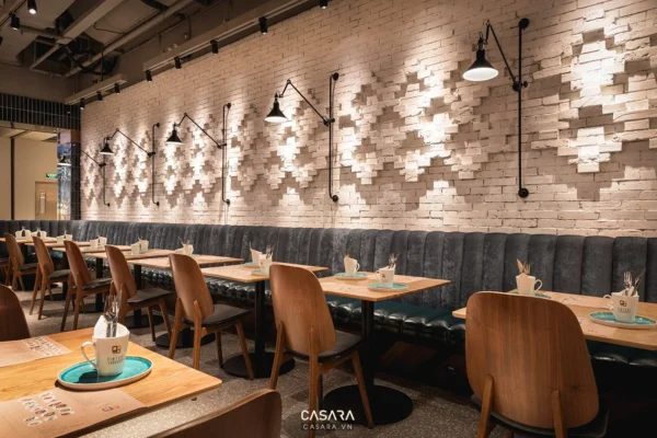 Không gian quán cà phê hiện đại với tường gạch trắng và đèn chiếu sáng.