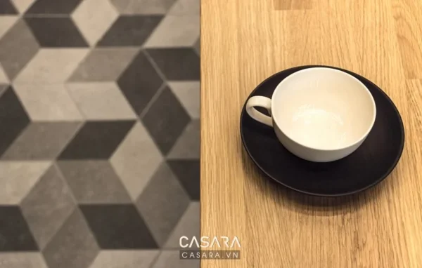 Góc bàn với gạch lát hoa và tách trà trắng tinh tế.