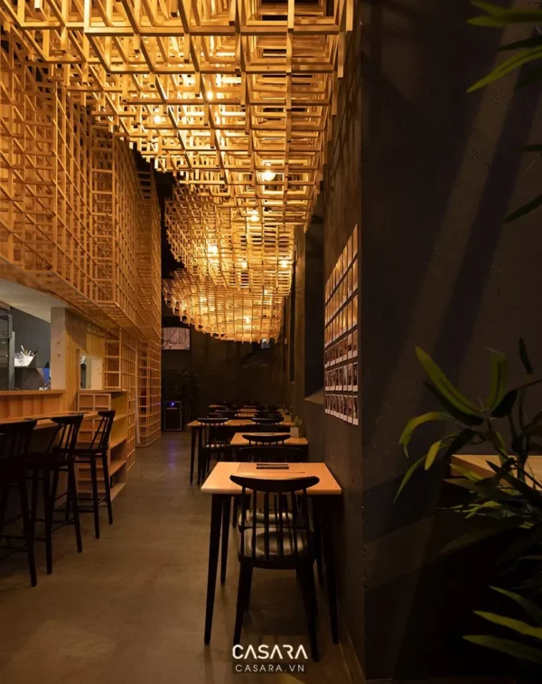 Không gian quán cafe thiết kế độc đáo với trần gỗ và ánh sáng ấm áp.