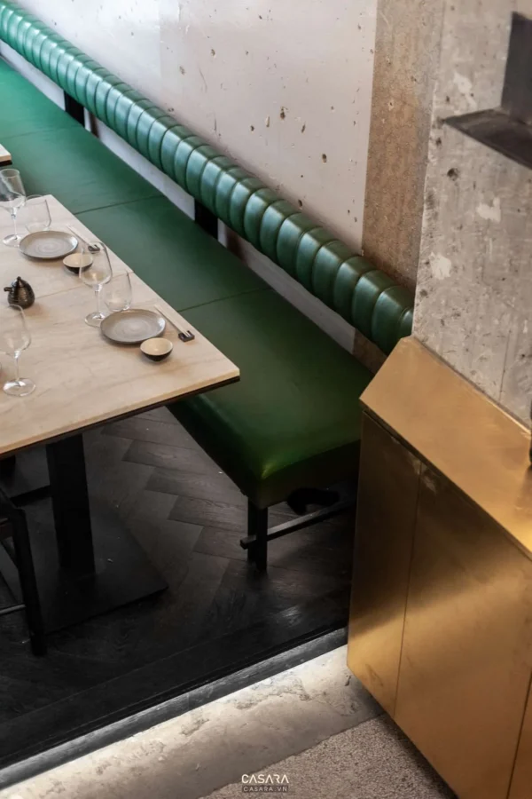 Góc bàn ăn hiện đại với ghế sofa xanh lục và nội thất sang trọng.