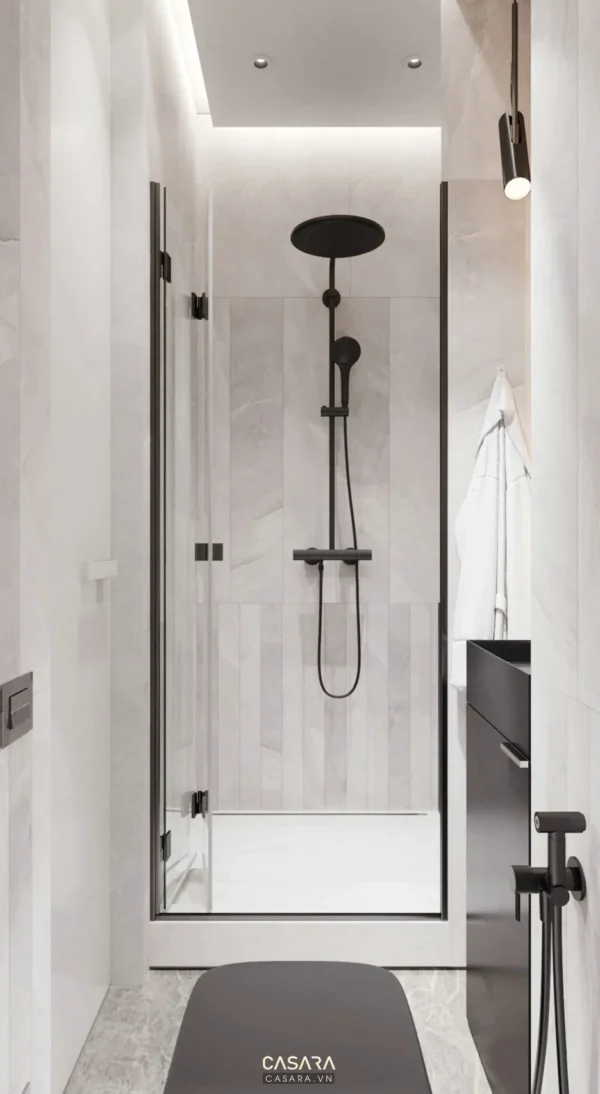 Phòng tắm hiện đại, sang trọng với vòi sen đen và gạch ốp trắng tinh tế.