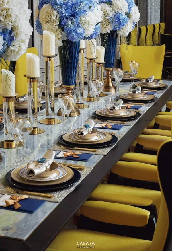 Bàn tiệc sang trọng với hoa tươi và bộ đồ ăn tinh tế.