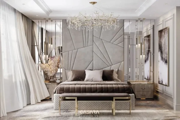 Phòng ngủ sang trọng với đầu giường ấn tượng và đèn chùm tinh tế.