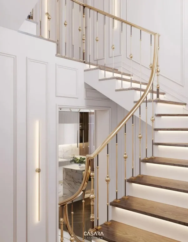 Cầu thang xoắn ốc sang trọng với lan can vàng tinh tế.