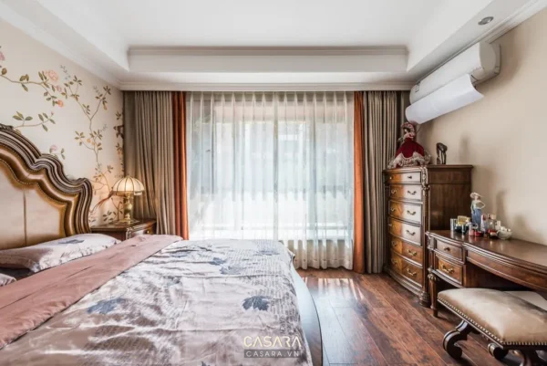 Phòng ngủ sang trọng với giường lớn, rèm cửa trang nhã và nội thất gỗ.