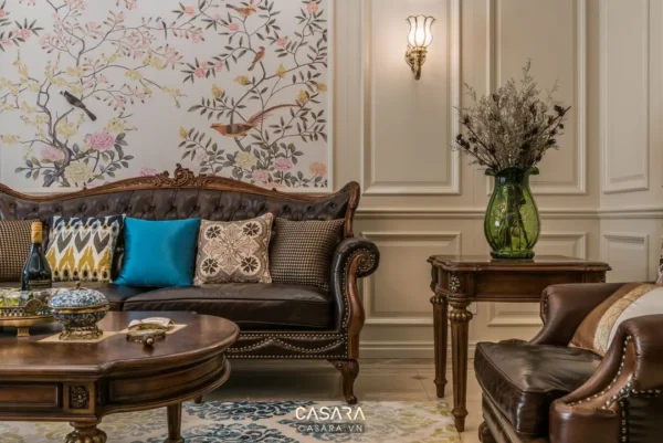 Phòng khách cổ điển với sofa da nâu và giấy dán tường họa tiết chim.