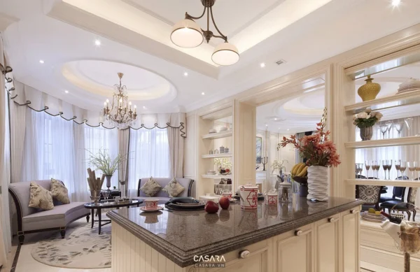 Phòng khách và khu bếp sang trọng, thiết kế cổ điển, tông màu trắng chủ đạo.