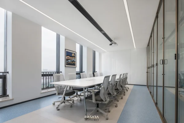 Phòng họp hiện đại, sáng sủa với bàn họp trắng và ghế xoay.