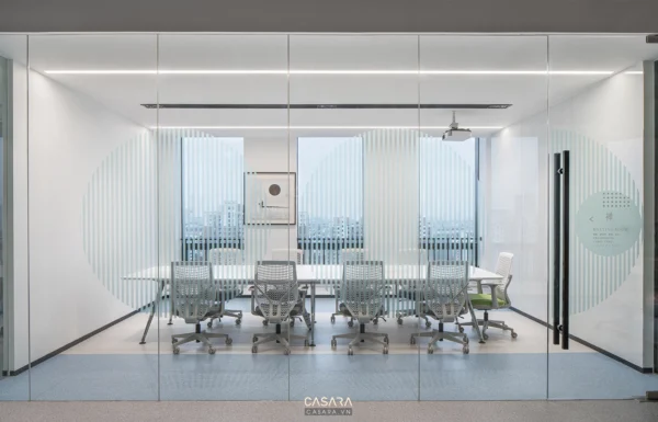 Phòng họp hiện đại với cửa kính lớn, ánh sáng dịu nhẹ và nội thất tối giản.