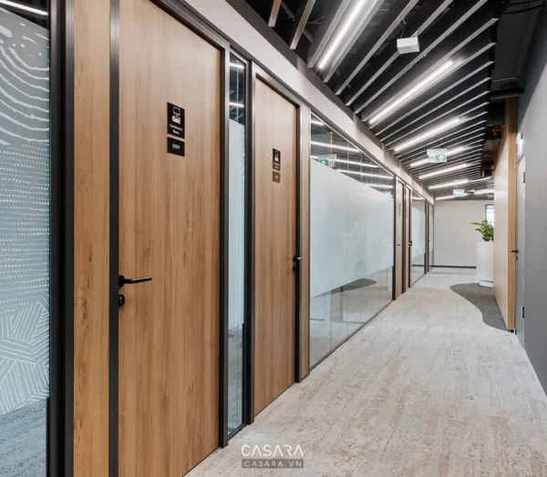 Hành lang văn phòng hiện đại với các cửa kính và gỗ.
