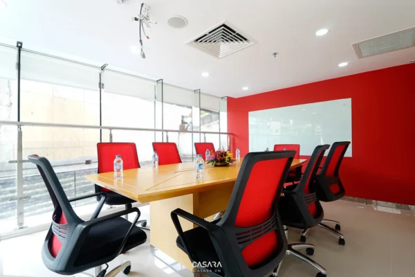 Phòng họp hiện đại với bàn gỗ và ghế đỏ đen sang trọng.