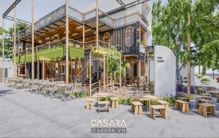 Quán cafe không gian mở có mặt tiền xanh, bàn ghế ngoài trời và ánh sáng ấm