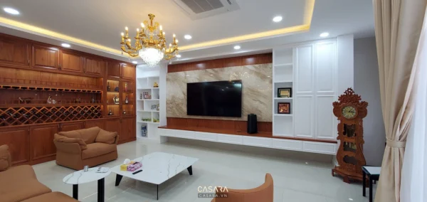 Phòng khách rộng rãi, thiết kế sang trọng với nội thất gỗ và đèn chùm.