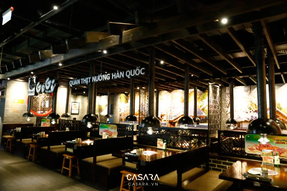 Nhà hàng phong cách Hàn Quốc có booth ngồi gỗ sáng, bàn ăn gọn, menu rõ, ánh sáng đều và khách dùng bữa theo nhóm.