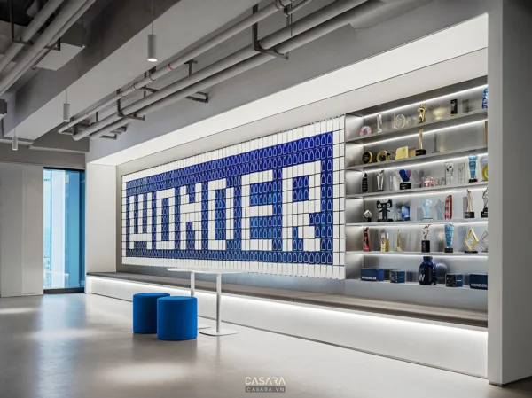 Không gian văn phòng hiện đại với điểm nhấn logo độc đáo và kệ giải thưởng.