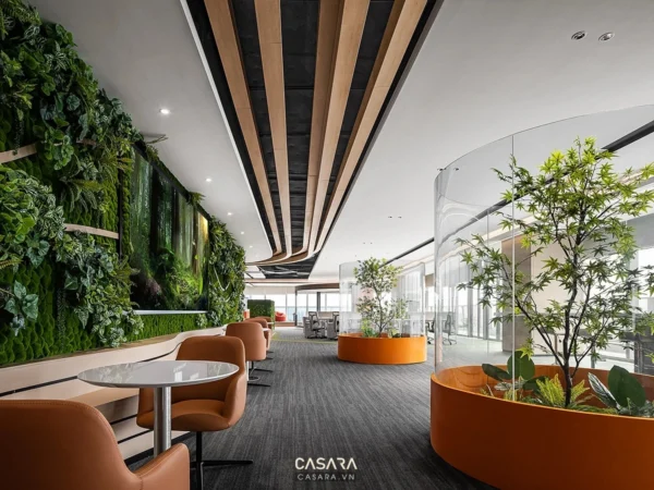 Không gian văn phòng hiện đại với tường cây xanh và nội thất cam nổi bật.