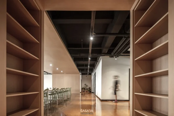 Hành lang gỗ dẫn vào không gian mở với người đang đi.