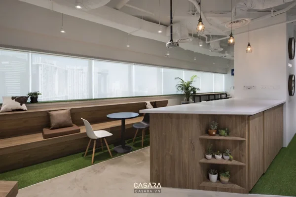 Khu vực thư giãn văn phòng hiện đại với thảm cỏ nhân tạo và bàn bar.