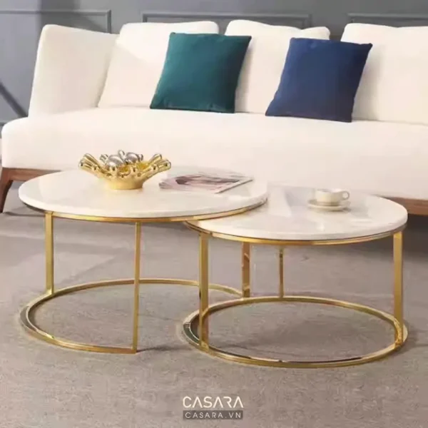 Phòng khách hiện đại với sofa trắng, bàn tròn vàng sang trọng.