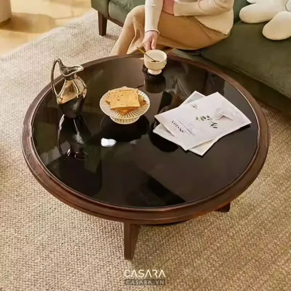 Bàn tròn gỗ bóng loáng bày đồ uống và đồ ăn nhẹ ấm cúng.