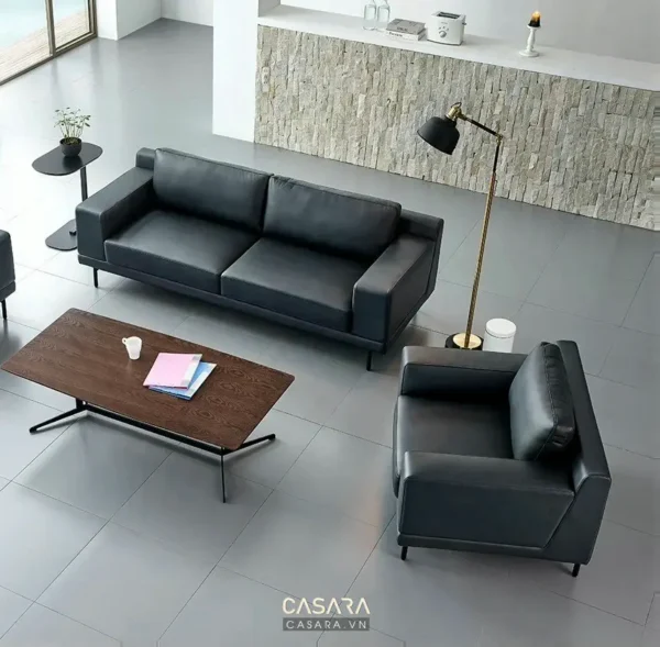 Phòng khách hiện đại với sofa đen, bàn trà gỗ và đèn sàn.