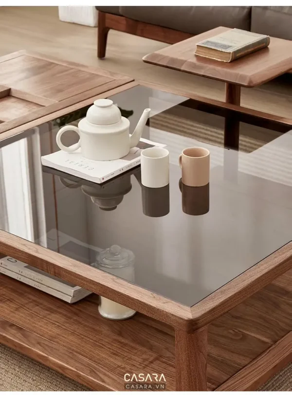 Bàn trà gỗ kính hiện đại, bày biện ấm trà và sách báo tinh tế.