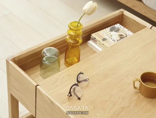 Bàn gỗ sáng màu bày lọ hoa và vài món đồ trang trí nhỏ xinh.