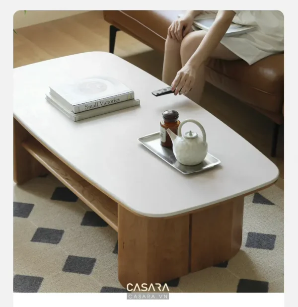 Bàn trà trắng hiện đại, bày biện sách, tách trà và đồ trang trí.