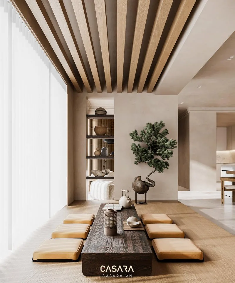 Ảnh căn hộ chung cư phong cách Japandi có sofa thấp, bàn trà tròn, gỗ sáng, cây xanh và thảm vải