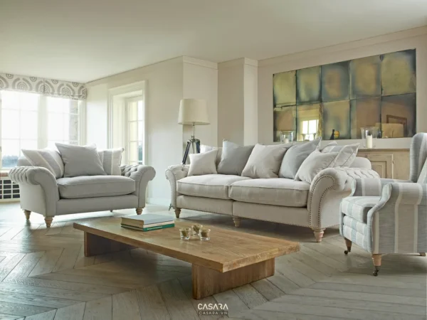 Phòng khách tân cổ điển sáng màu với sofa bo cong, bàn trà thấp và ánh sáng tự nhiên