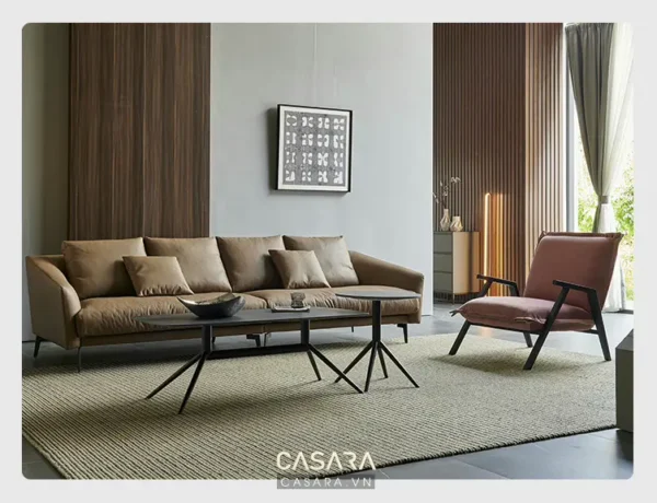 Phòng khách hiện đại với sofa màu be, ghế bọc da và tranh trừu tượng.