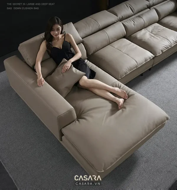 Người phụ nữ thư giãn trên chiếc ghế sofa êm ái màu xám nhạt hiện đại.