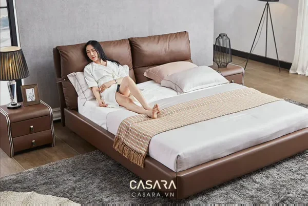 Người phụ nữ thư giãn trên chiếc giường da màu nâu sang trọng.