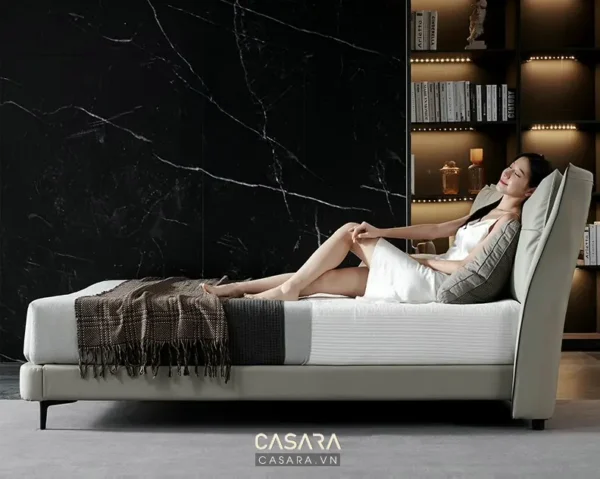 Người phụ nữ thư giãn trên chiếc ghế sofa dài hiện đại, sang trọng.