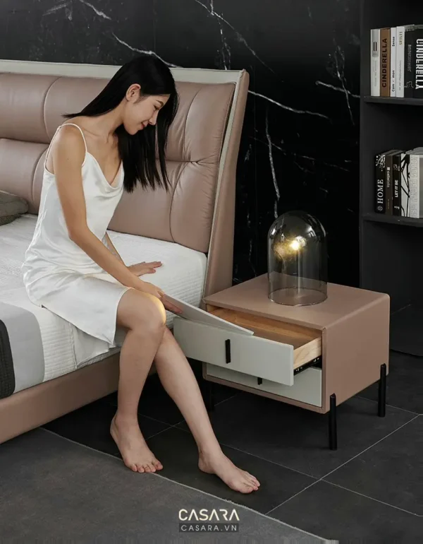 Người phụ nữ thư giãn trên giường trong phòng ngủ hiện đại, sang trọng.