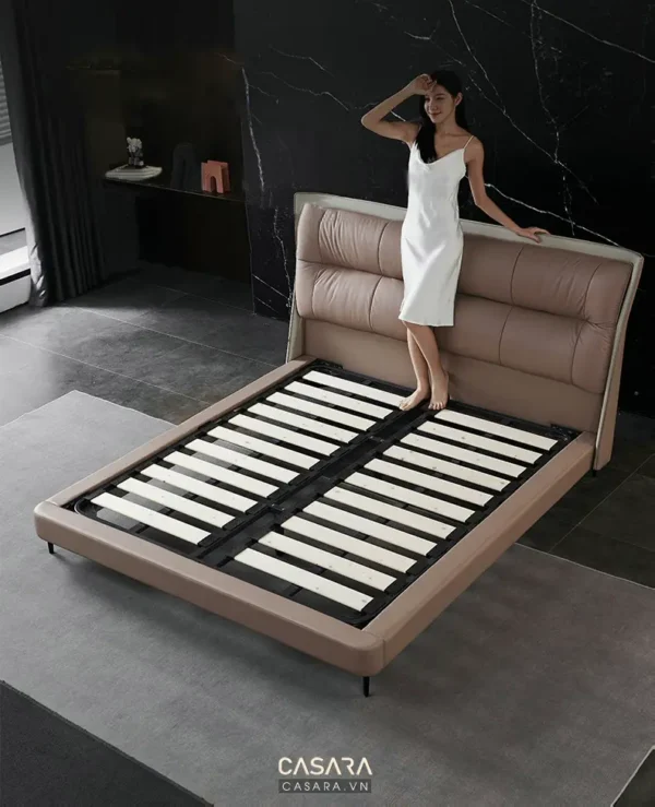 Người mẫu tựa vào giường ngủ hiện đại, sang trọng trong phòng tắm.