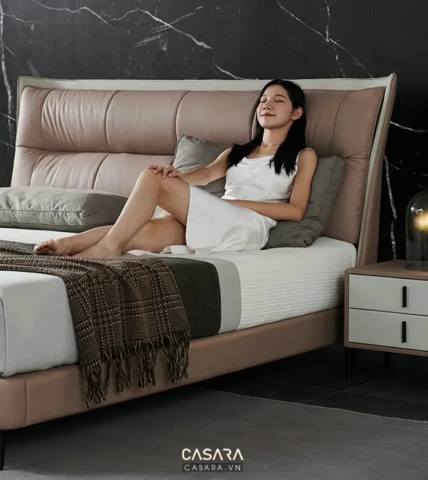 Người phụ nữ thư giãn trên giường ngủ sang trọng, hiện đại.