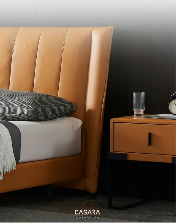 Phòng ngủ hiện đại với giường da cam và tủ đầu giường tinh tế.